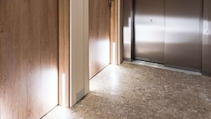 A hallway with wooden doors and a metallic elevator. - Travi Boutique By Holi 11 (Saint Julian's)
