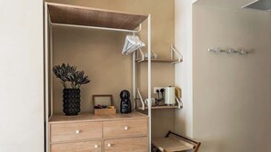 Ein kleines Zimmer mit einem Holzschrank, einem Tisch und einem Stuhl.