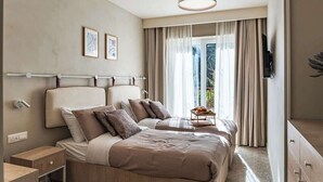 A modern hotel room with two beds, a bedside table, a TV, and a window with curtains. - Travi Boutique By Holi 17 (Tas-Sliema)