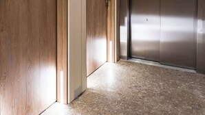 A hallway with wooden doors and a metallic elevator. - Travi Boutique By Holi 17 (Tas-Sliema)