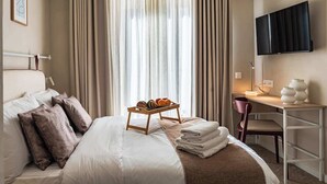 A hotel room with a bed, a desk, a TV, and a window with curtains. - Travi Boutique By Holi 18 (Saint Julian's)