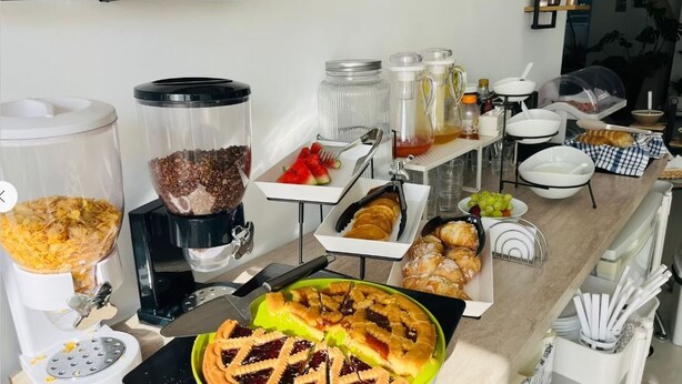A buffet setup with various food items, including a pie, pastries, and a coffee station. - 8Villa (St. Julian's)
