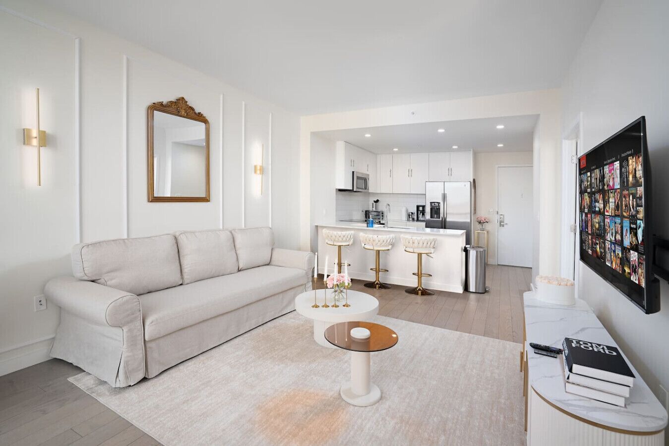 Una sala de estar moderna con un sofá, una mesa de centro y una cocina al fondo.