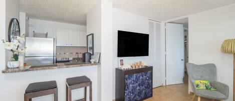 Un espace de vie compact comprenant une cuisine, un coin repas et un coin salon.