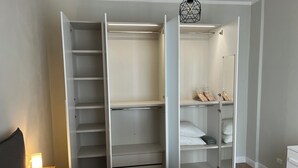 A bedroom with a bed, a wardrobe, and a bedside table.