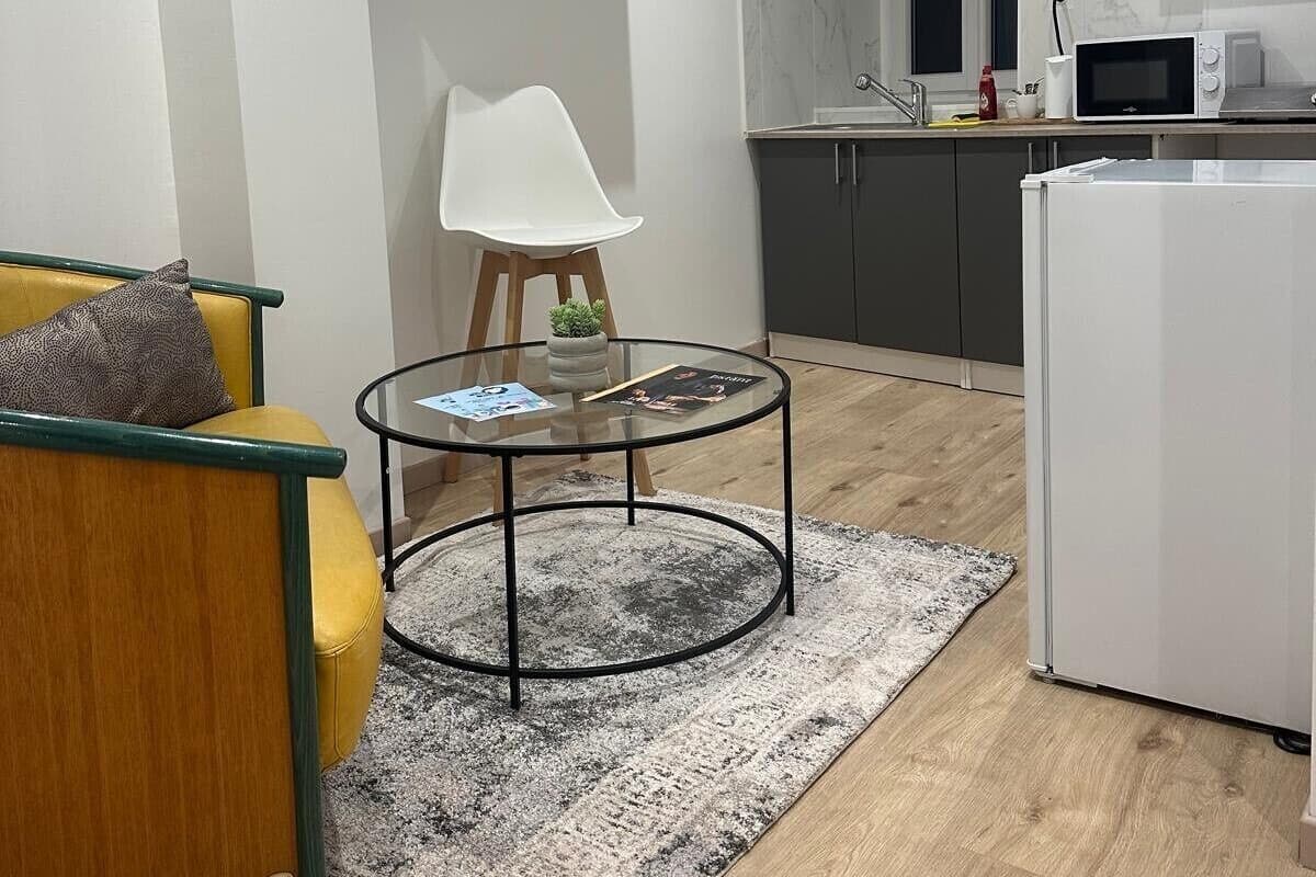 Ett modernt kök med mörka skåp, ett vitt kylskåp och en mikrovågsugn placerad på bänkskivan.