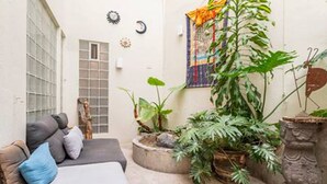 Une pièce confortable avec un lit, une fenêtre et une plante en pot.