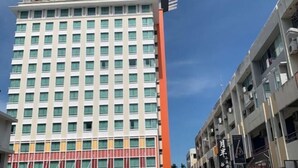 A hotel with a modern facade, multiple floors, and a prominent sign at the top. - A Residence - A Member of The Luxury Stay Group (Kota Kinabalu)