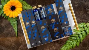 A set of black and blue boxes with gold accents, arranged on a marble surface with green ferns and a yellow flower. - A Residence - A Member of The Luxury Stay Group (Kota Kinabalu)