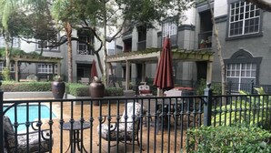 A courtyard with a pool, outdoor seating, and a building with balconies. - Pool View 2 Bedroom/2 Bath Condo in Houston's Medical Center (Houston)