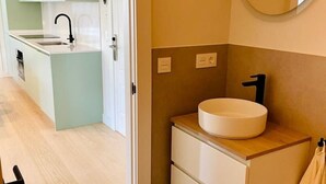 Une salle de bain moderne avec un lavabo, un miroir et des toilettes.