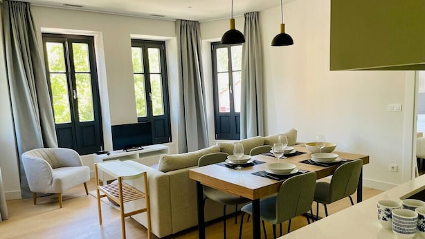Un espace repas moderne avec une table en bois, des chaises et un canapé.