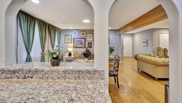 Amplia sala de estar con encimera de mármol, un sofá y un comedor con una silla.