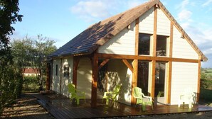 A single-story building with a sloped roof, wooden beams, and large windows. - Chalet du Menhir - SAINT-MICAUD (SAINT-MICAUD)