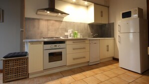 Una cocina compacta equipada con estufa, horno, microondas y refrigerador.