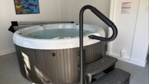 Un bain à remous doté d’un siège intégré et de marches pour faciliter l’accès.