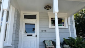 Une maison avec une porte blanche et une fenêtre portant le numéro 1102.