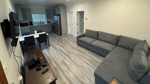 Ein kompakter Wohnbereich mit Küchenzeile, Essbereich und einer Sitzecke mit Sofa.