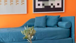 A blue sofa with matching cushions, a small potted plant, and a magazine on a round table. - A.R.T. Loft Trastevere (Roma)
