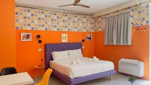A bedroom with a purple bed, orange walls, a ceiling fan, a desk, and a chair. - A.R.T. Loft Trastevere (Roma)