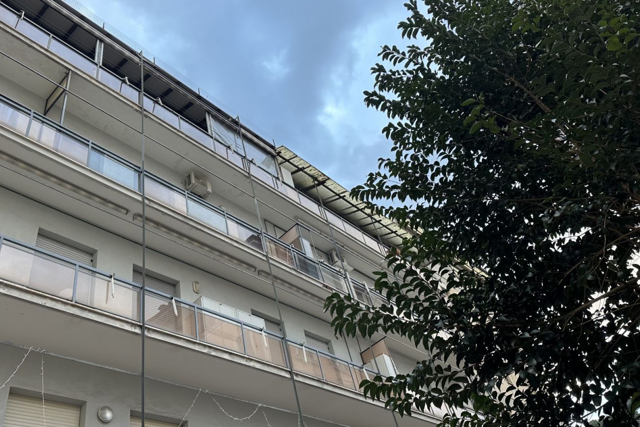 A multi-story building with balconies, railings, and windows.