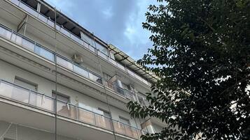A multi-story building with balconies, railings, and windows.