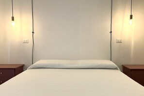 A bed with a white sheet, two bedside tables, and two wall-mounted lights. - A41 - Ancona, two-room apartment in the center (Ancona)