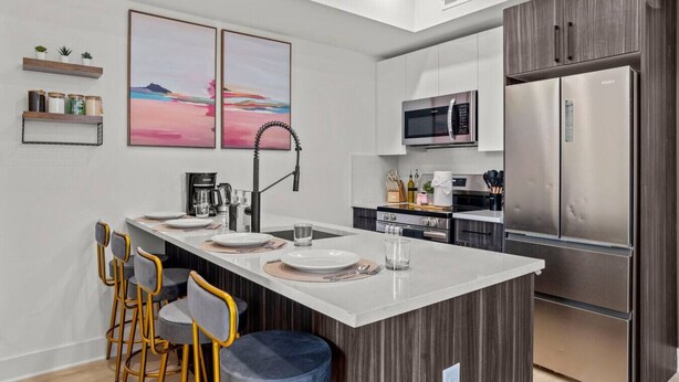 A modern kitchen with a central island, stainless steel appliances, and a minimalist design.