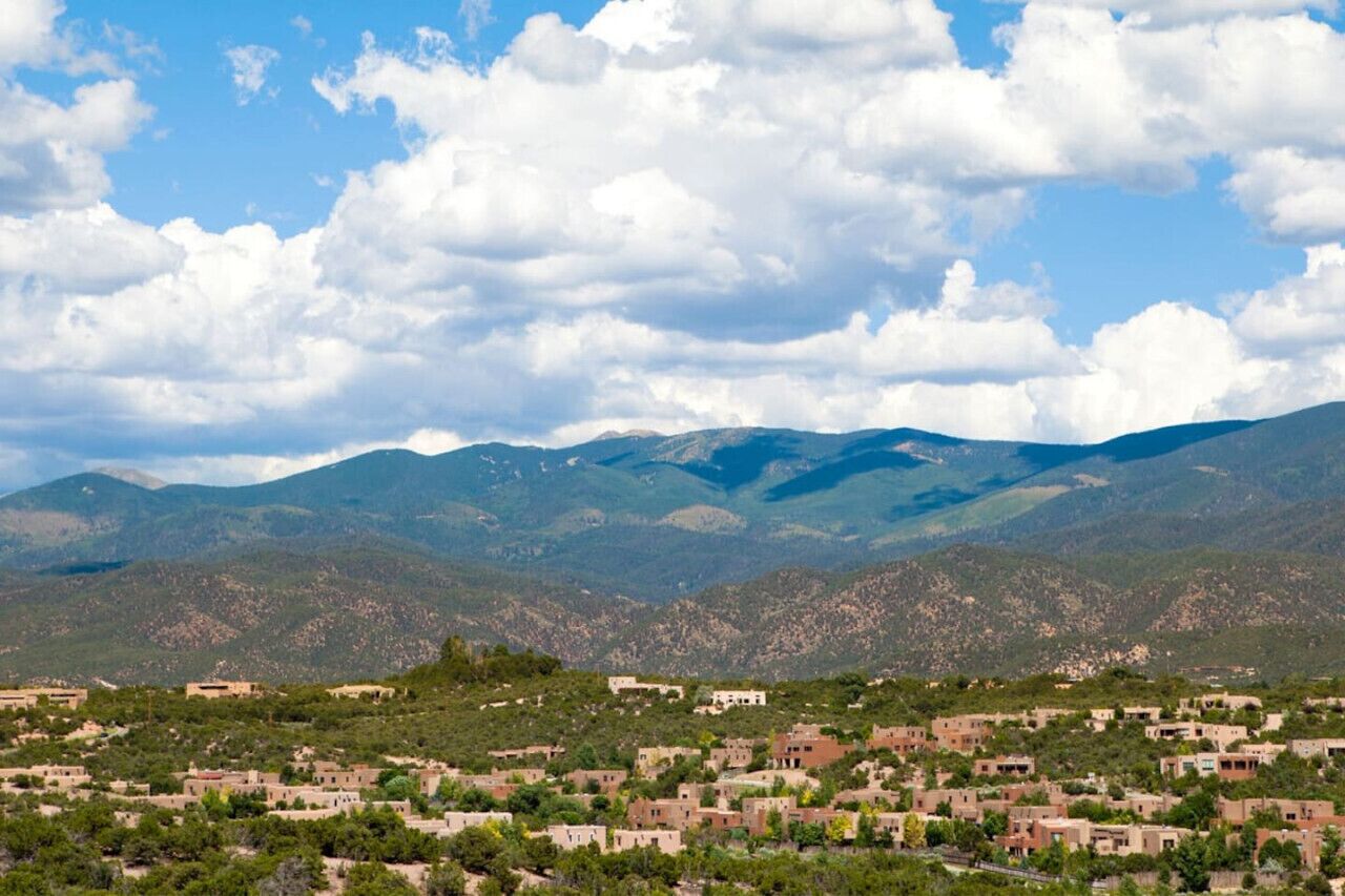 Un paysage montagneux avec un village au premier plan.
