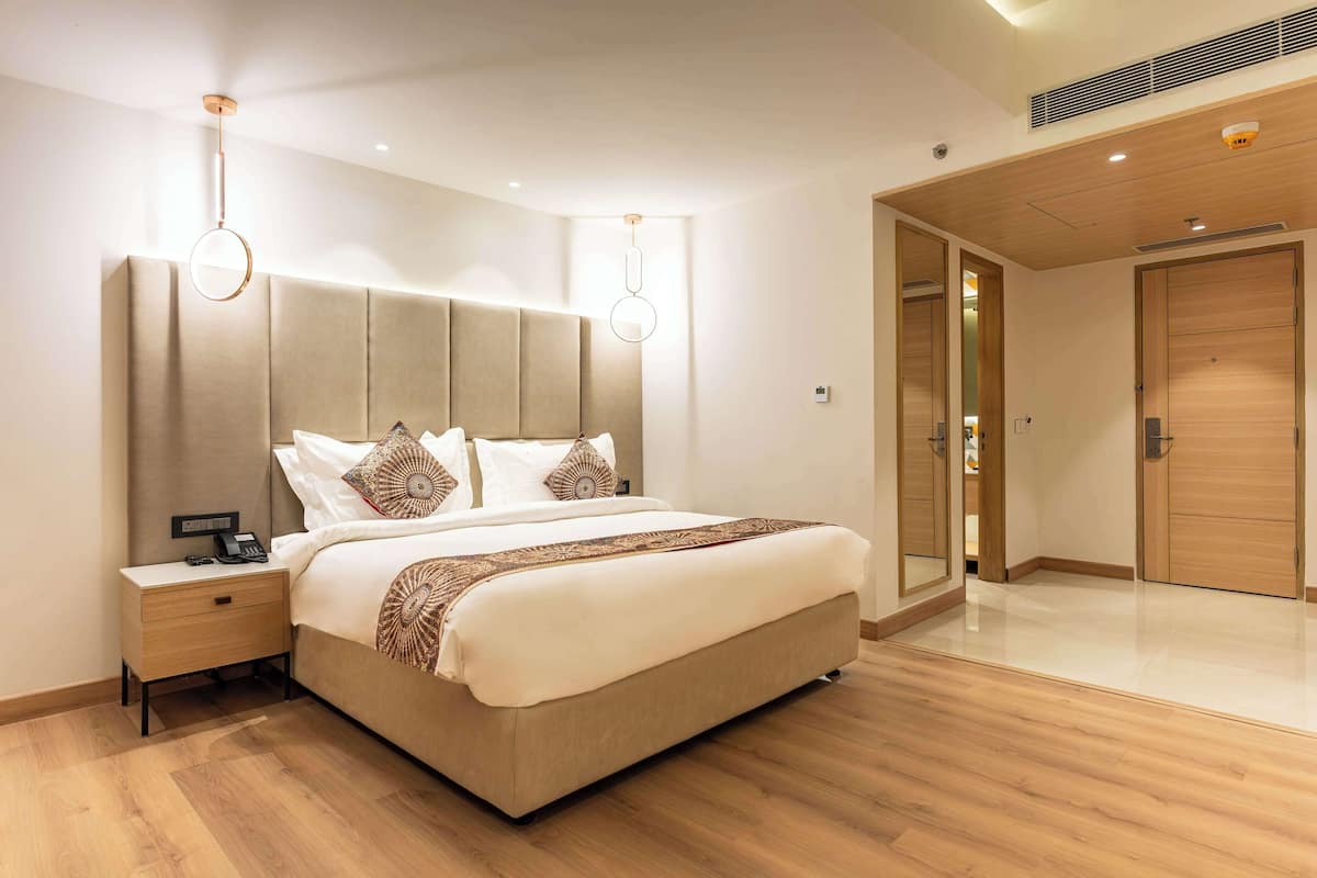 Quarto moderno com cama grande, mesas de cabeceira e closet espaçoso.