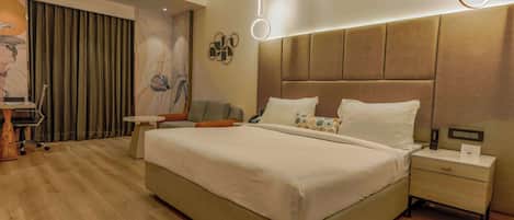 A modern hotel room with a large bed, bedside tables, a desk, and a chair.