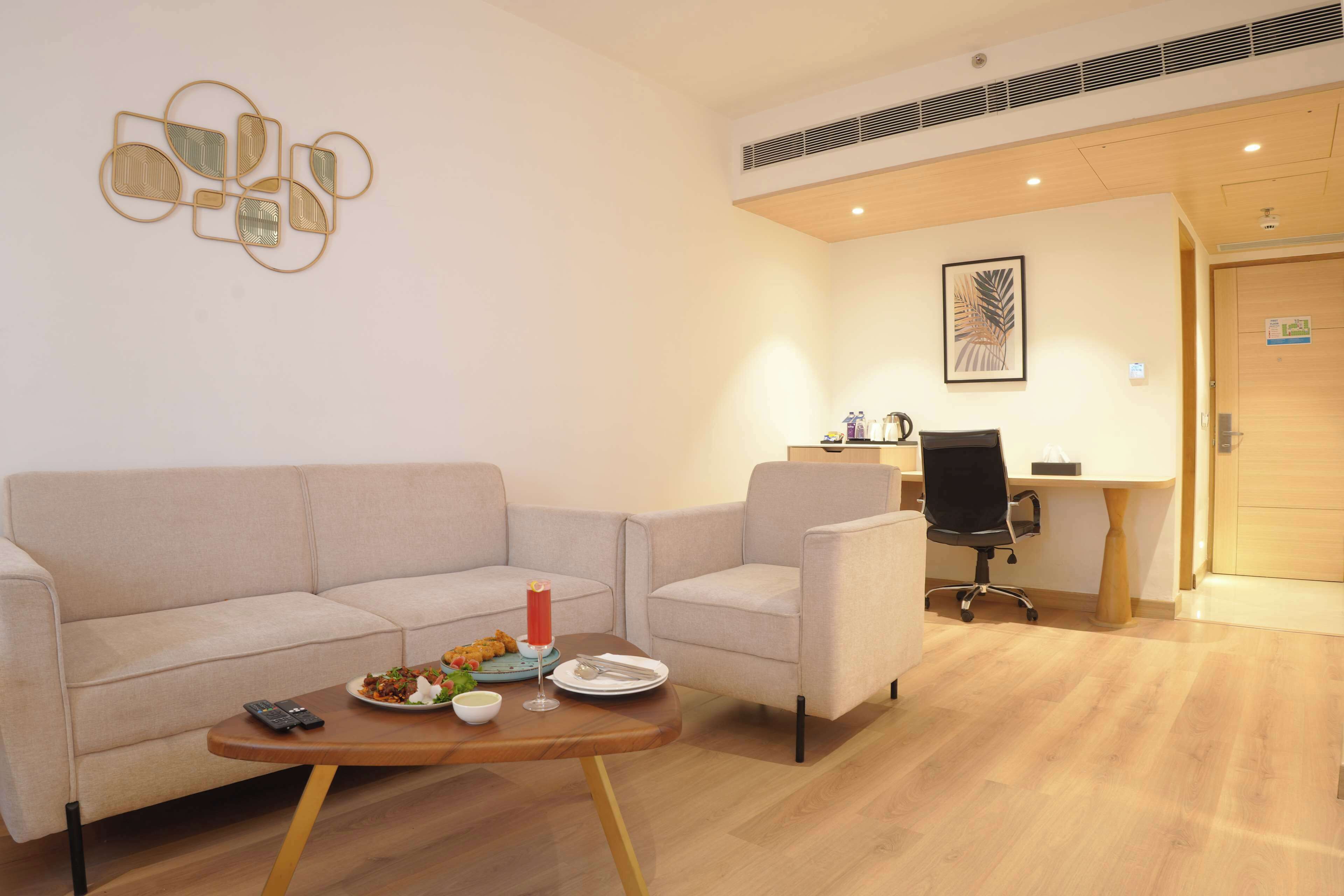 Una sala de estar moderna con un sofá, una mesa de centro con comida y un escritorio con una silla.