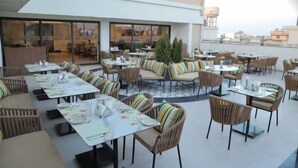 An outdoor dining area with multiple tables and chairs, some with cushions. - Best Western Ah1 Amritsar (Amritsar)
