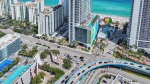 A high-rise hotel with a pool and beach view, surrounded by other buildings and a busy road. - Best View in Lyfe Hollywood Beach (Hollywood)