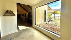 Un ambiente spazioso con un'ampia porta scorrevole in vetro che si apre su un giardino.