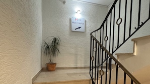 A staircase with a sign indicating the direction to the Main Taunus Hotel.