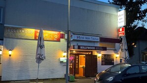 A building with a sign for 'Bollywood Indian Restaurant' and 'Hotel Main Taunus'.
