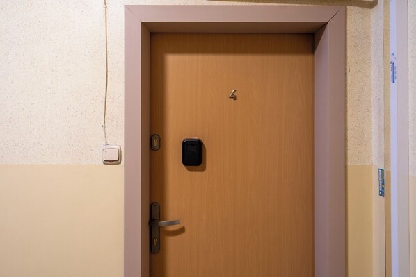 A closed wooden door with a key lock and a small electronic keypad.