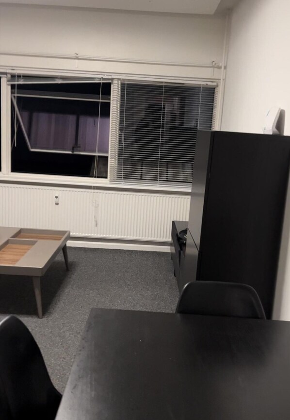 Enjoy a peaceful stay in this serene room with a window, radiator, and comfortable seating area.