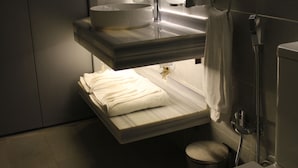 Une salle de bain équipée de toilettes, d’un lavabo et d’un porte-serviettes.