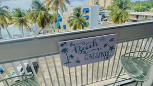 Un balcon orné d’une pancarte sur laquelle on peut lire : « La plage vous appelle… ».