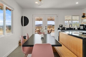 Enjoy meals in the kitchen with an island, sink, and coffee machine, and dine in the adjacent area with a table and chairs.