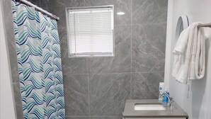Ein Badezimmer mit Dusche, Waschbecken und Toilette.