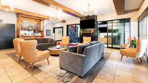 A modern living room with a fireplace, sofas, and a Christmas tree. - Rustic Luxe on Main | Spa, Dining & Charm On-Site at the Treasure Mountain Inn (Park City)