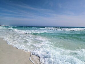 A beach with waves approaching the shore.