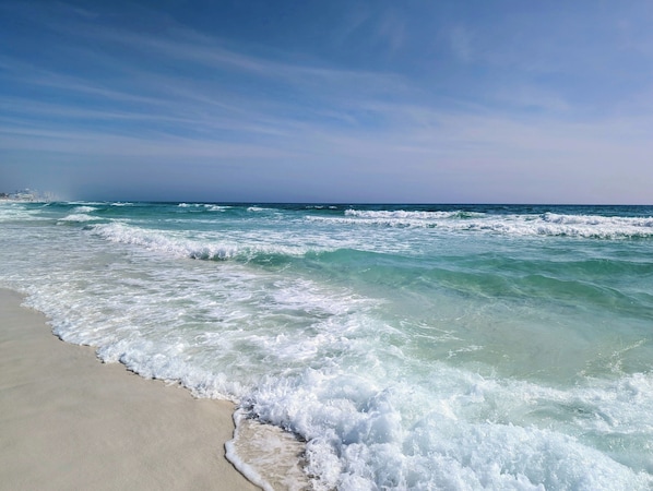 A beach with waves approaching the shore.