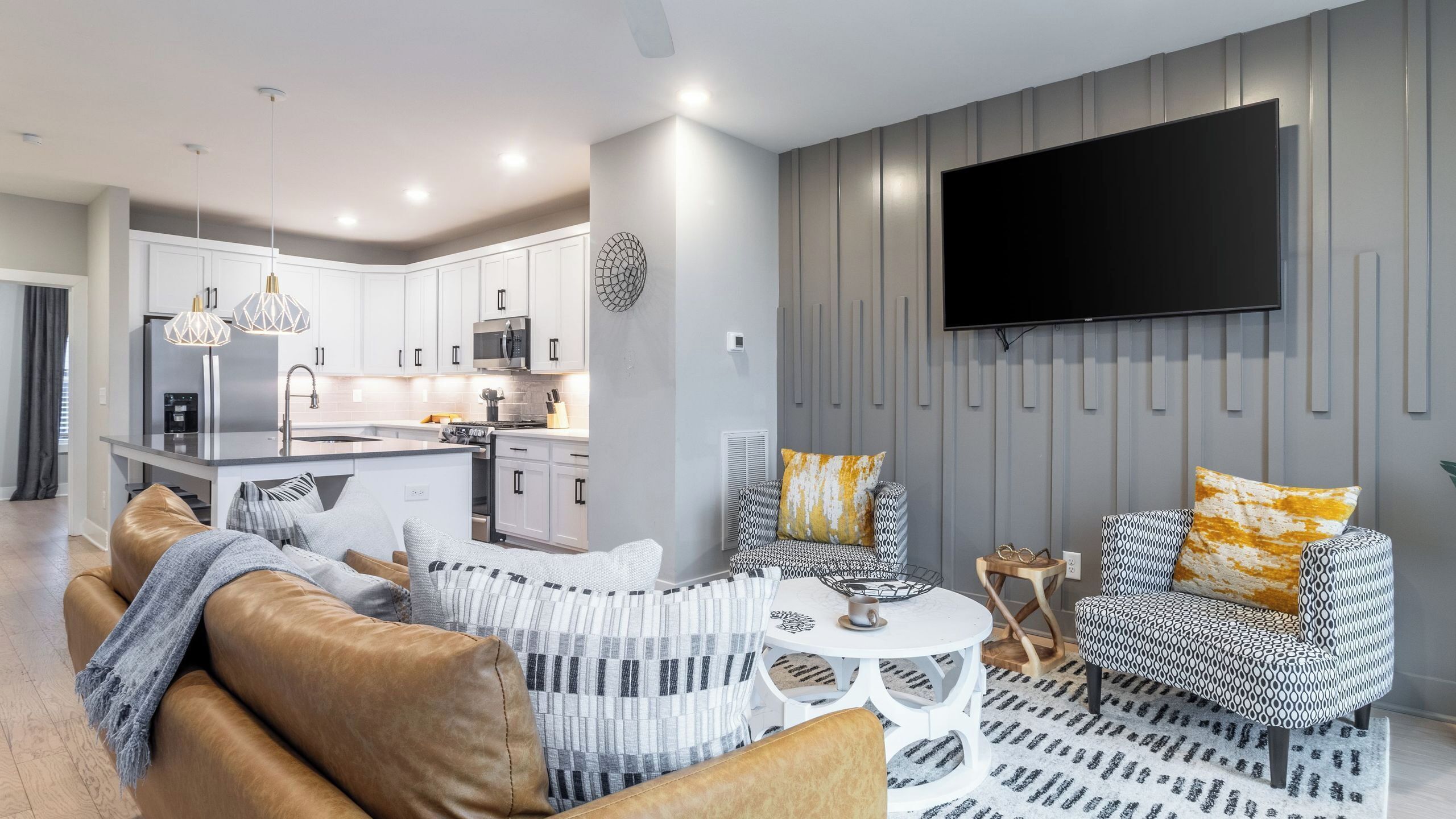 A modern living room with a sofa, patterned armchair, and a coffee table.