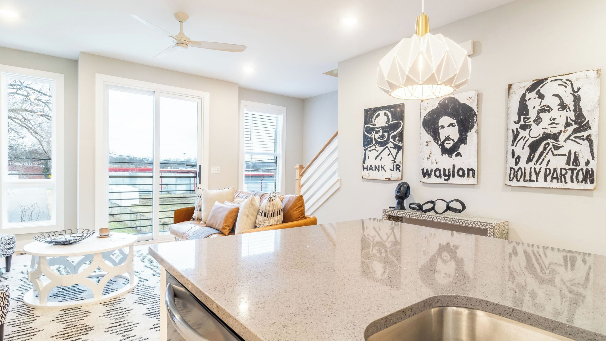 A modern kitchen with a granite countertop, a built-in sink, and a ceiling fan.