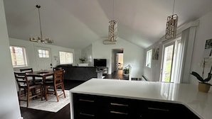 A modern kitchen with dark cabinetry, a central island, and pendant lighting. - Redlands farm (Oregon City)