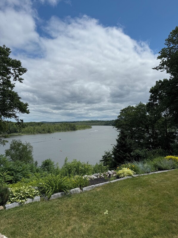 A lake with boats, surrounded by lush greenery and trees.